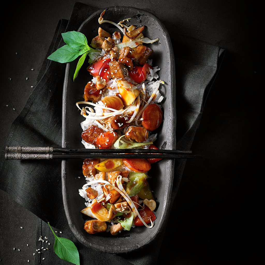 Frisch zubereitete Teriyaki Wok Sensation mit gebratenem Gemüse, würziger Teriyaki-Sauce und asiatischem Topping in einer Schüssel serviert.